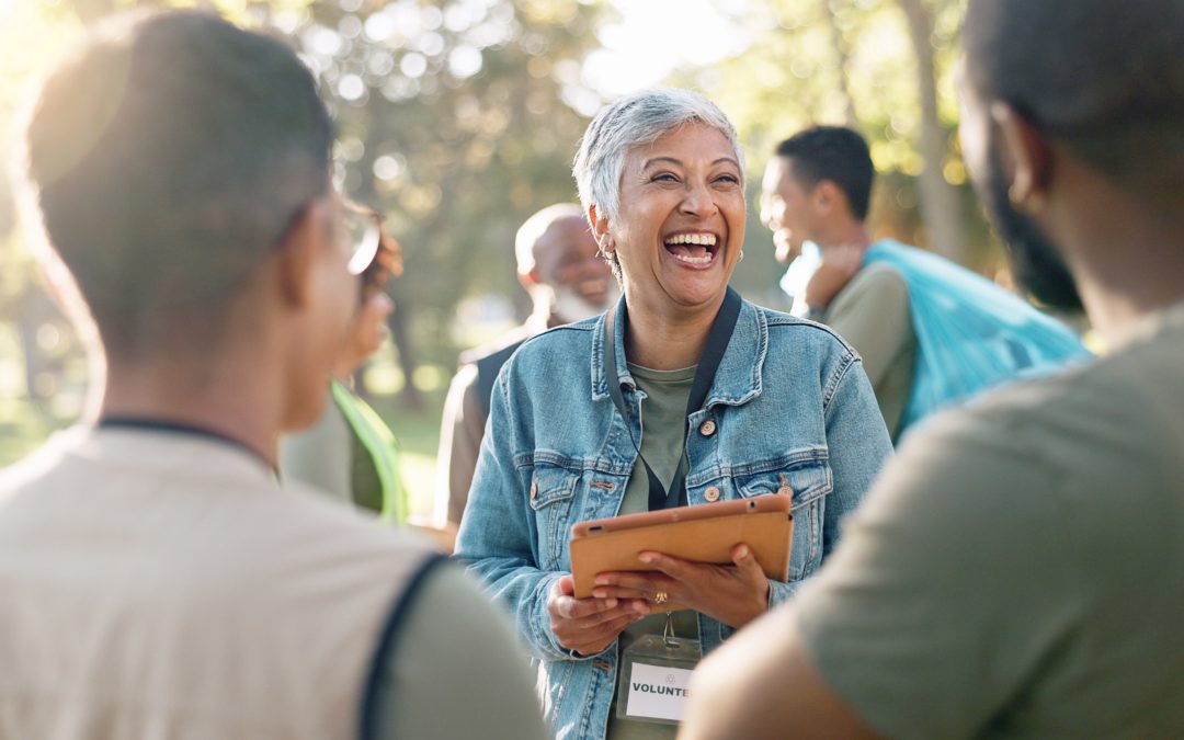 A group of volunteers connects at an outdoor community event that was coordinated with an online member directory